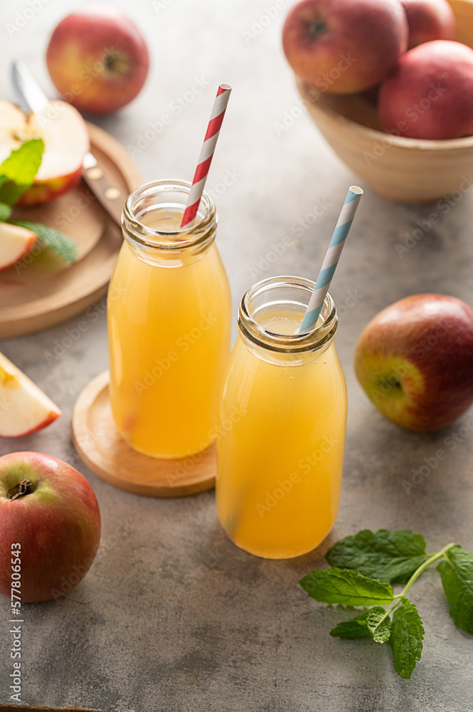 Apple juice glass bottles, with fresh red apples, wooden background. Apple juice glass bottles, with fresh red apples, wooden background.