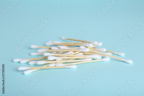 Wooden cotton buds on light blue background