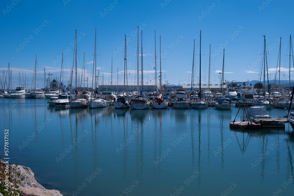 A small calm bay with a mooring for boats, yachts and catamarans against the backdrop of a sunny day, background