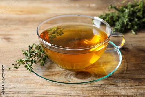 Aromatic herbal tea with thyme on wooden table