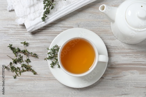 Aromatic herbal tea with thyme on white wooden table, flat lay