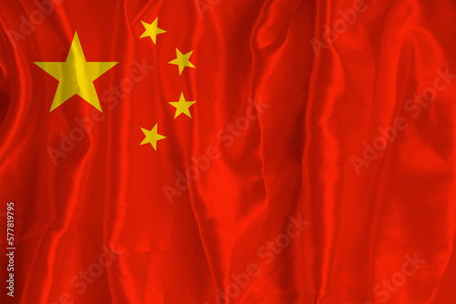 Flag of China on silk background is a great national symbol. Fabric texture The official state symbol of the country.