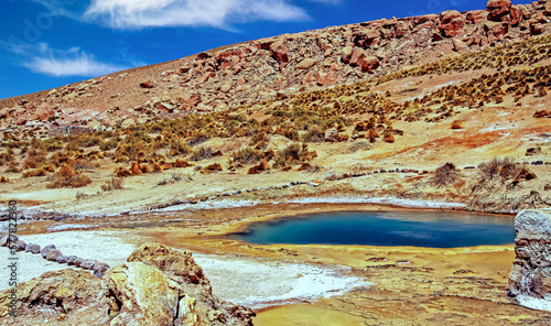 Beautiful colorful volcanic landscape, geothermal valley with natural dark blue hot pool, dry arid desert mountain - El Tatio geysers field, Atacama desert, Chile