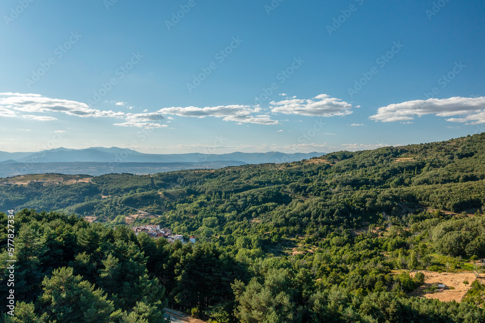 Aerial drone view of landscape sunny day in spring in northern Extremadura, Spain, with road, trees, plants and rocks.