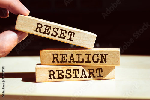 Wooden blocks with words 'Reset, realign, restart'. photo