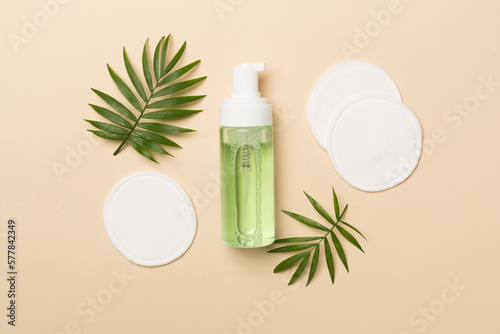 Foto Foaming facial cleanser and with eco pads on color background, top view