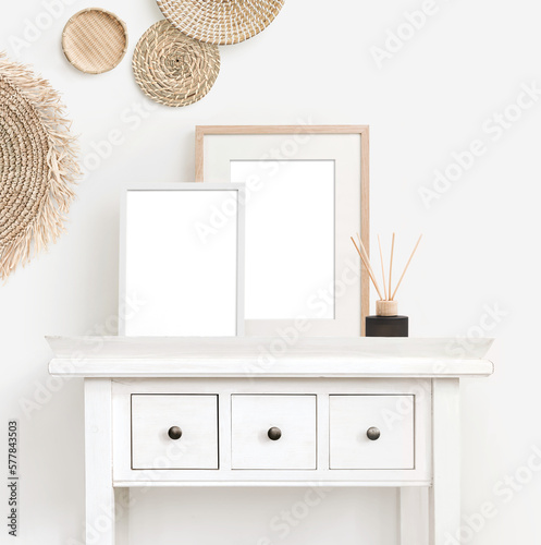 bright minimalist boho picture / photo frame mockup with two frames on a rustic white desk, with natural baskets hanging on a white wall, square format, ideal for social media, front view