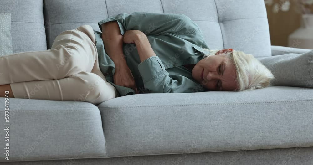Stockvideo Sick upset aged woman touch belly, suffers from abdomen ache