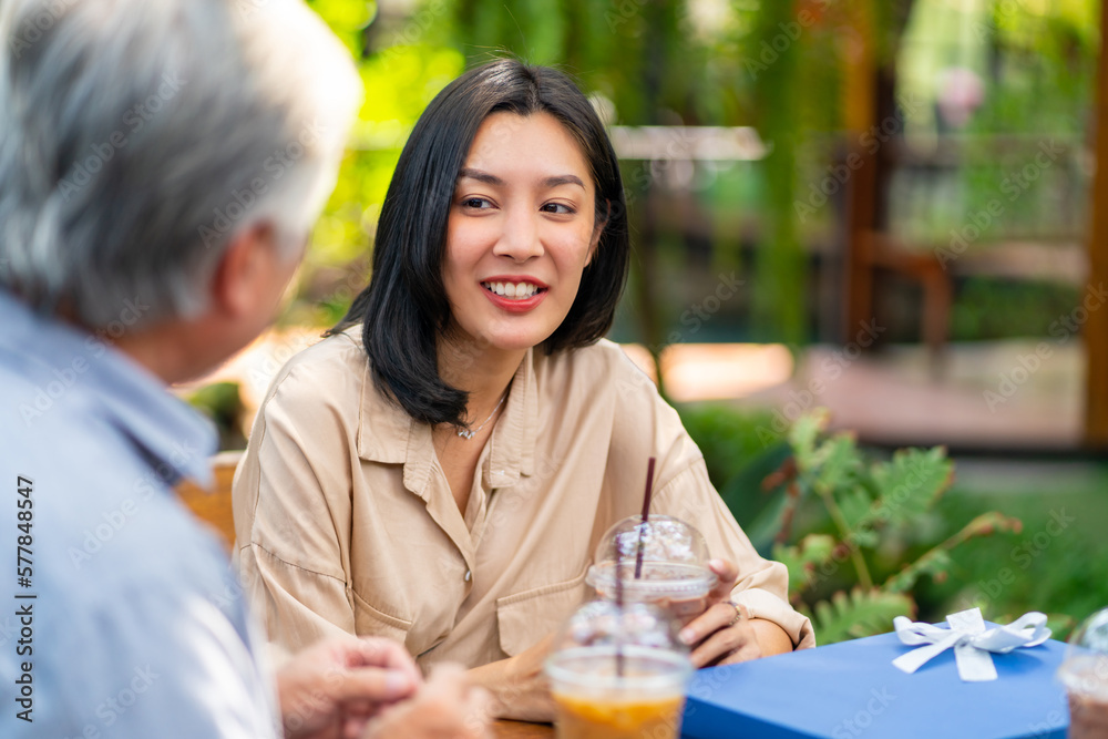 Happy Asian couple and elderly father having lunch eating food together at outdoor cafe restaurant on summer holiday vacation. Family relationship, fathers day and older people health care concept. Happy Asian couple and elderly father having lunch eating food together at outdoor cafe restaurant on summer holiday vacation. Family relationship, fathers day and older people health care concept.