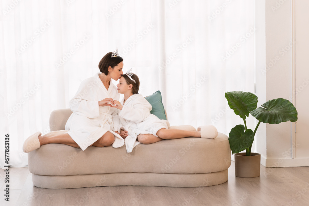 Loving Mother And Little Daughter Wearing Bathrobes And Crowns Bonding At Home Loving Mother And Little Daughter Wearing Bathrobes And Crowns Bonding At Home