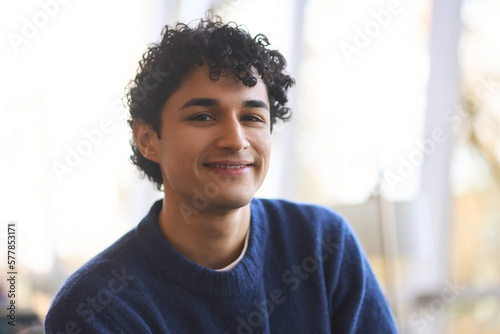 Portrait of a handsome smiling Latin American man, university student looking confidently at camera