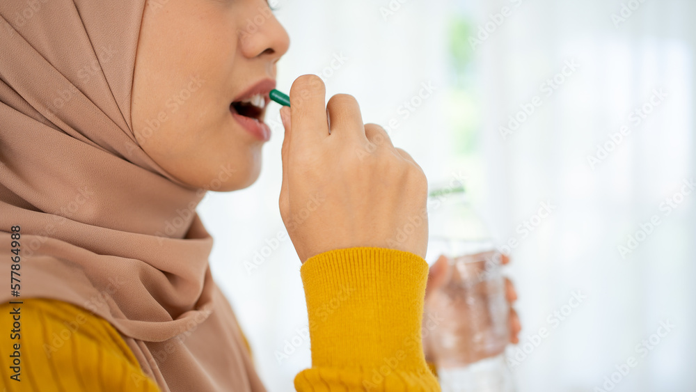 Diet, nutrition, healthy eating concept. Close Up Of Happy Smiling Asian Woman Taking Supplement Pill And Holding Glass Of Fresh Water In Morning, copy space Diet, nutrition, healthy eating concept. Close Up Of Happy Smiling Asian Woman Taking Supplement Pill And Holding Glass Of Fresh Water In Morning, copy space