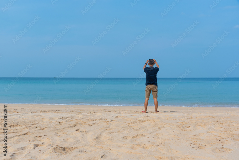 A senior adult male taking photograph on the beach. A senior adult male taking photograph on the beach.
