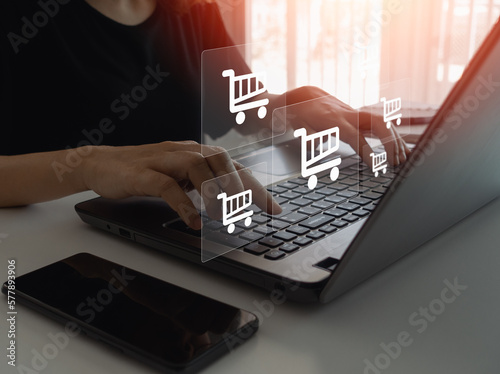 Foto Businesswoman hand typing on laptop computer keyboard with online shopping concept