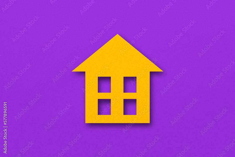 Obraz premium Yellow paper cut out house shape isolated on purple paper background.