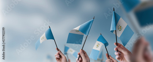 A group of people holding small flags of the Guatemala in their hands photo