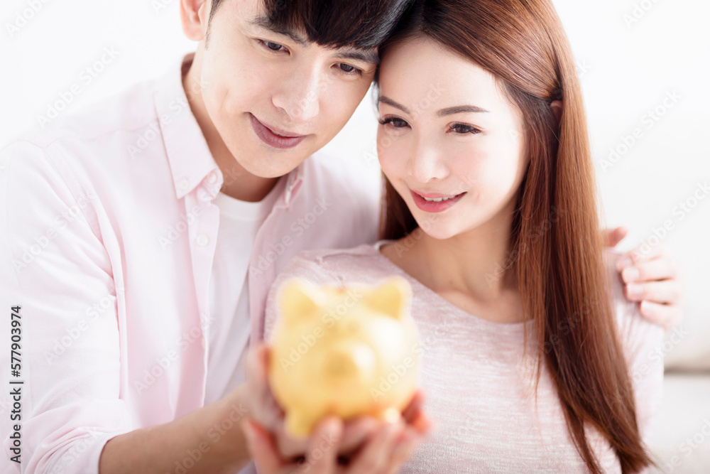 Happy  Couple holding Piggybank and Making Savings For Future