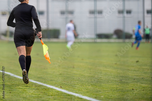 A female assistant referee runs by the touchline photo