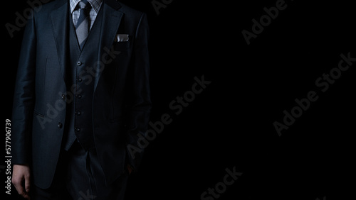 Elite businessman in a luxury custom-made suit against black background.