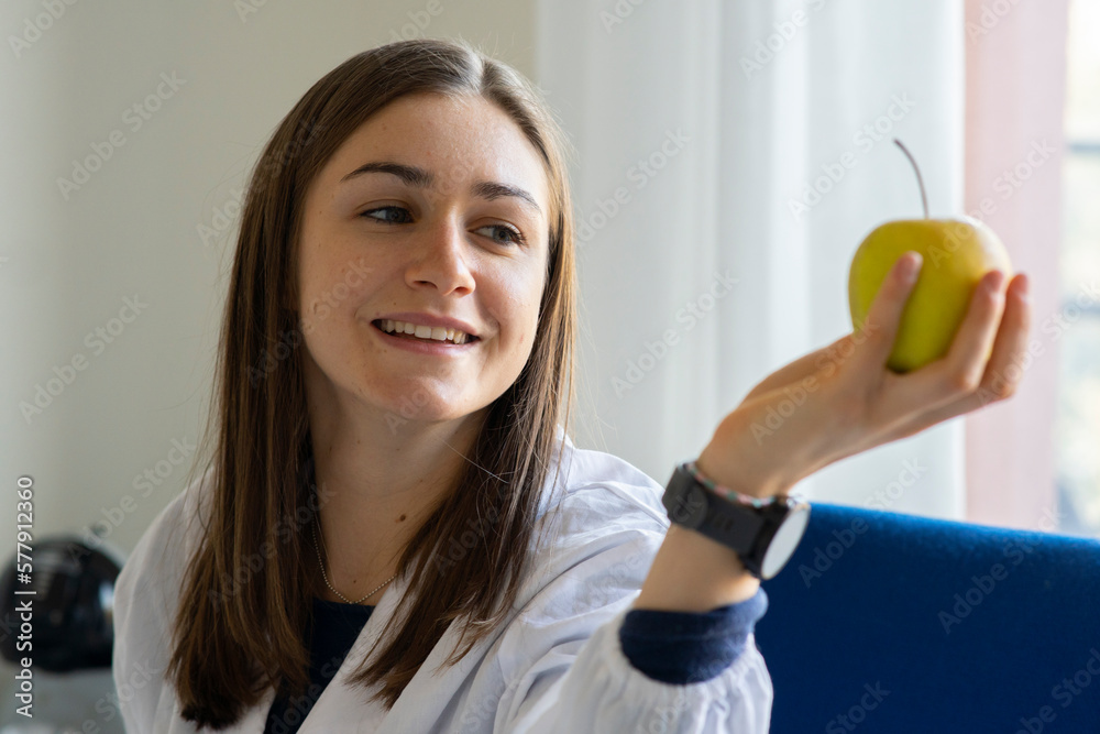 Smiling female nutritionist shows an apple. Healthy eating concept Smiling female nutritionist shows an apple. Healthy eating concept