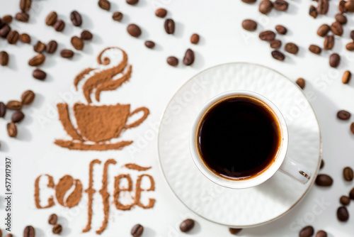 Hot drinks. The inscription "Coffee", coffee beans and a cup of coffee or tea is made of ground coffee on a white isolated background. Banner.