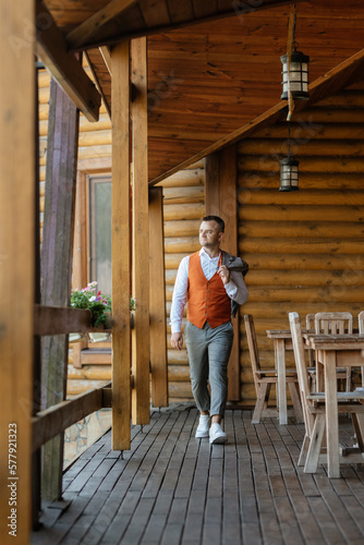 portrait of the groom in a gray suit and an orange vest © omelnickiy