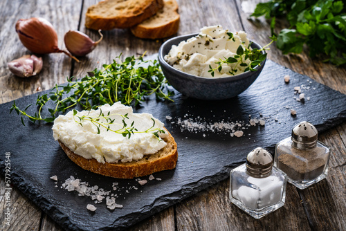 Cottage cheese sandwich with thyme on wooden table 