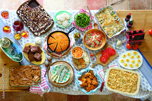 Overhead view of various fresh homemade food on table at home during potluck photo