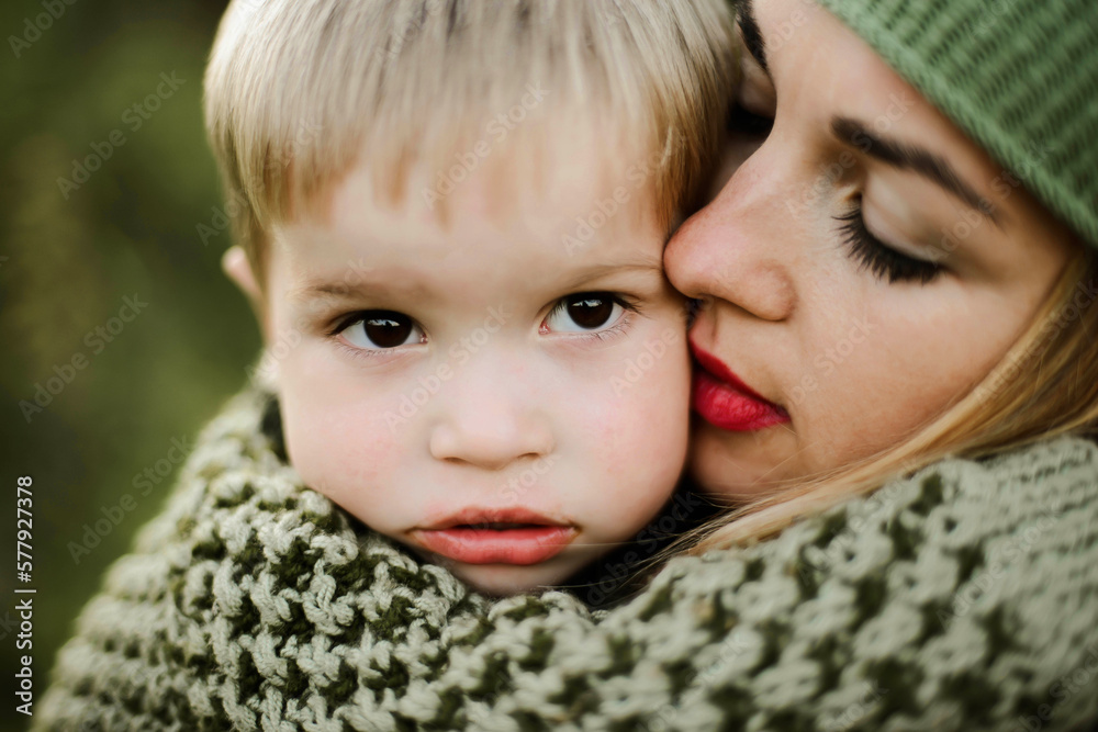 Close -up young mother hugs her little pretty son outdoor Close -up young mother hugs her little pretty son outdoor