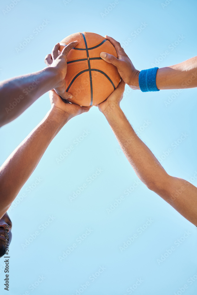 Teamwork, sports and hands on basketball ball with blue sky background in outdoor basketball court. Support, community and athletes ready for game, match and training for fitness and exercise in park