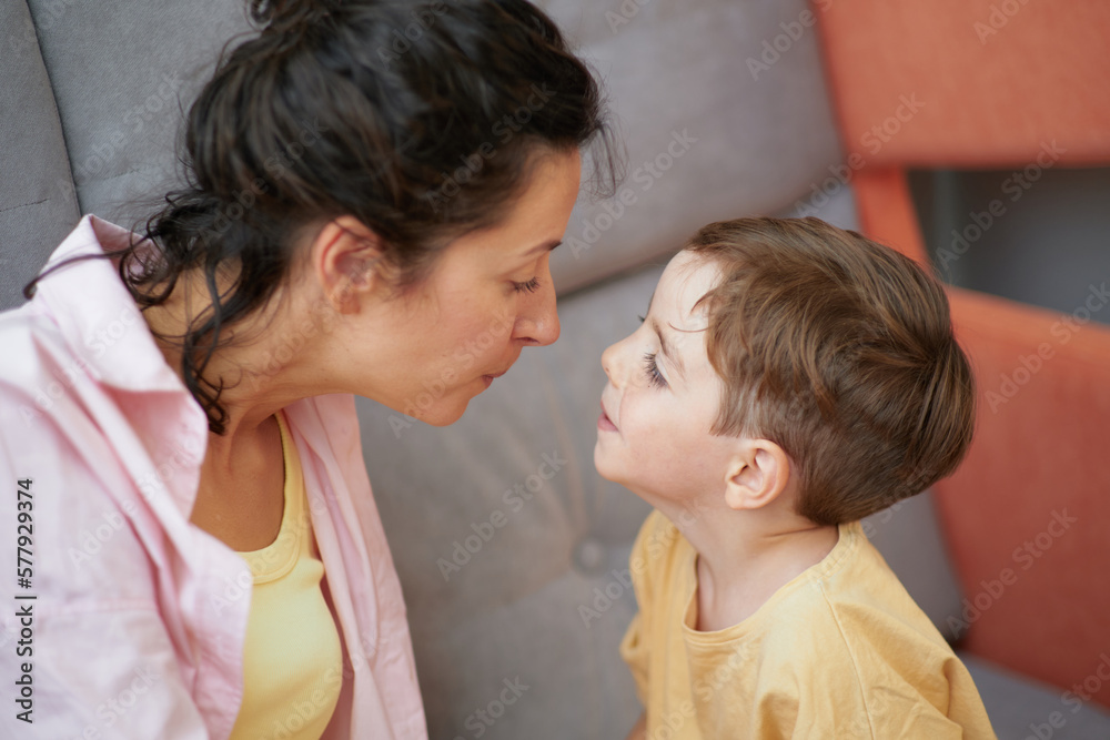 Happy family time together: mom and small child enjoy morning together sitting face to face at home. Loving parent female enjoy spending time with boy on weekend. High quality photo Happy family time together: mom and small child enjoy morning together sitting face to face at home. Loving parent female enjoy spending time with boy on weekend. High quality photo