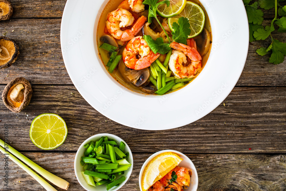 Thai seafood soup on wooden table
