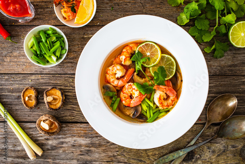 Thai seafood soup on wooden table
