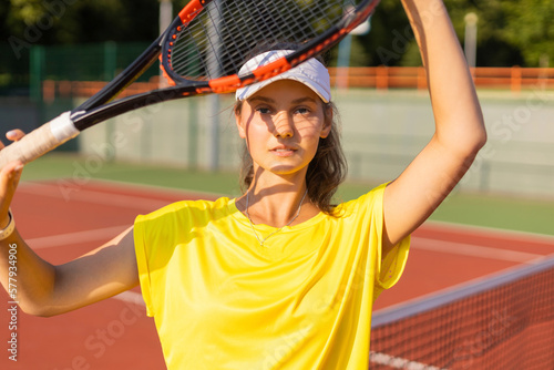 Pretty sportswoman with racquet at the tennis court. Healthy lifestyle.