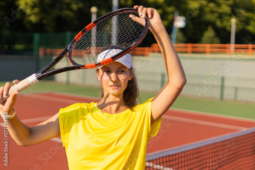 Pretty sportswoman with racquet at the tennis court. Healthy lifestyle.
