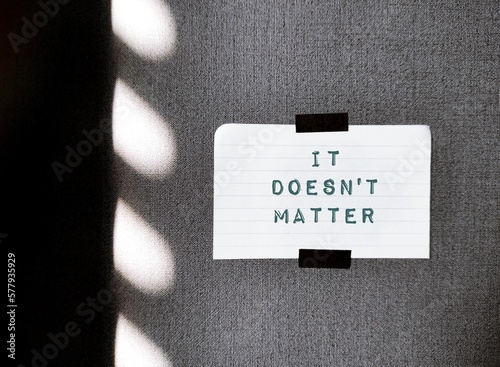 Bild auf Leinwand White note on grey wallpaper with text IT DOESN'T MATTER, concept of saying neve