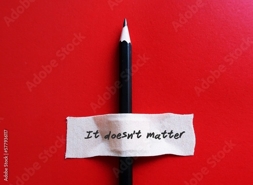Bild auf Leinwand A pencil on red background with plaster band aid written IT DOESN'T MATTER,  to