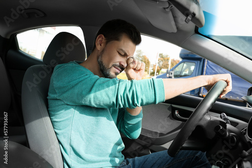 Sleepy tired man in his modern car