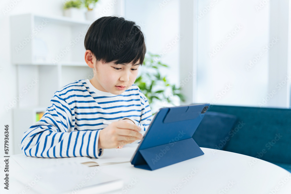 タブレットを見ながら勉強する男の子 タブレットを見ながら勉強する男の子