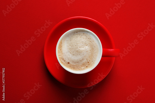 Fotobehang Cup with aromatic cappuccino on red background, top view