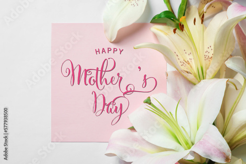 Fototapeta Naklejka Na Ścianę i Meble -  Happy Mother's Day greeting card and beautiful lily flowers on white background, flat lay