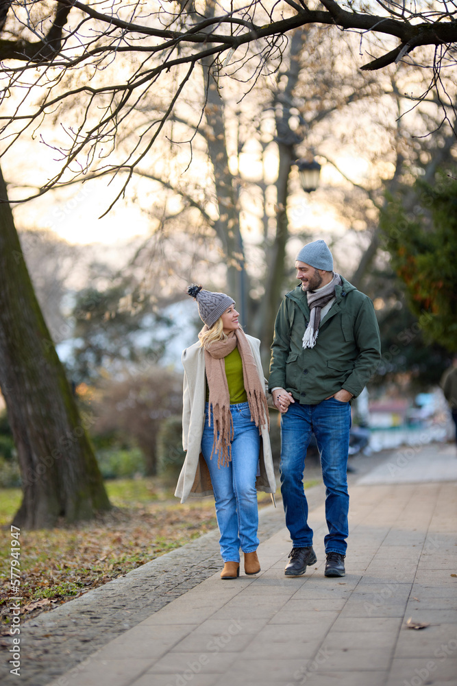 Fototapeta premium Romantic couple enjoying a walk in the park holding hands