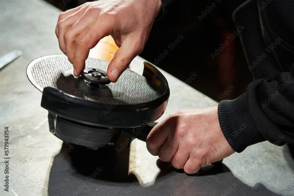 The hands of a Caucasian worker unscrew with their fingers the nut