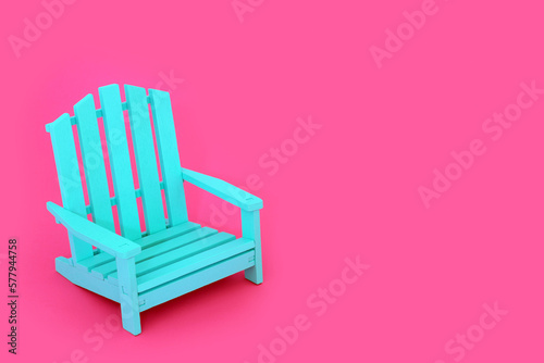 Time to relax composition with modern blue wooden slatted chair on vivid pink background. Minimal contemporary stylish furniture colour contrast concept.