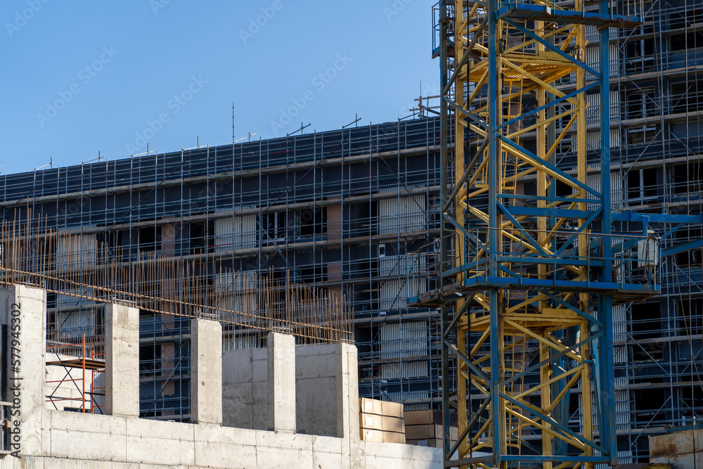 Wire steel rod to reinforce. Steel reinforcement structure of rebars for concrete pouring at construction site. Housing construction, apartment block with scaffolding Wire steel rod to reinforce. Steel reinforcement structure of rebars for concrete pouring at construction site. Housing construction, apartment block with scaffolding