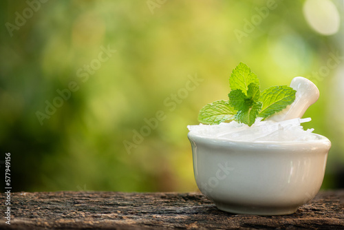 Menthol crystal and peppermint leaves on nature background.