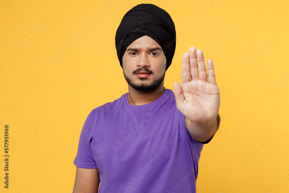 Strict serious devotee Sikh Indian man ties his traditional turban