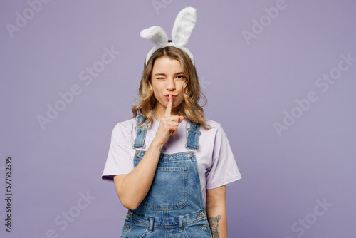 Fotografie Young secret woman wearing casual clothes bunny rabbit ears say hush be quiet with finger on lips shhh gesture isolated on plain pastel light purple background studio