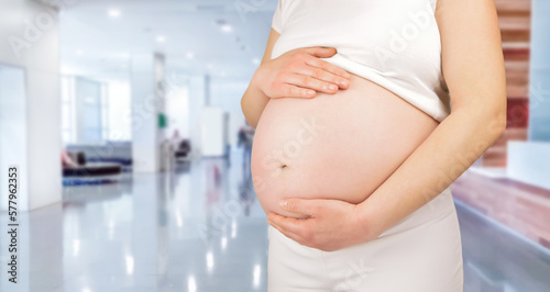 Closeup of a pregnant woman holding her tummy at hospital