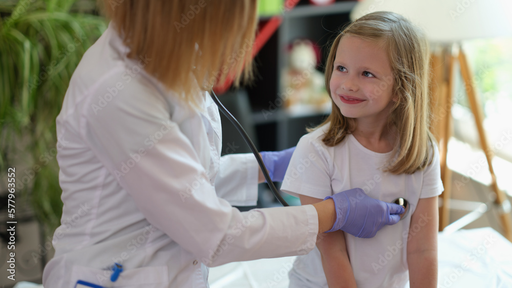 Obraz premium Female family doctor checks health of young patient in medical clinic.